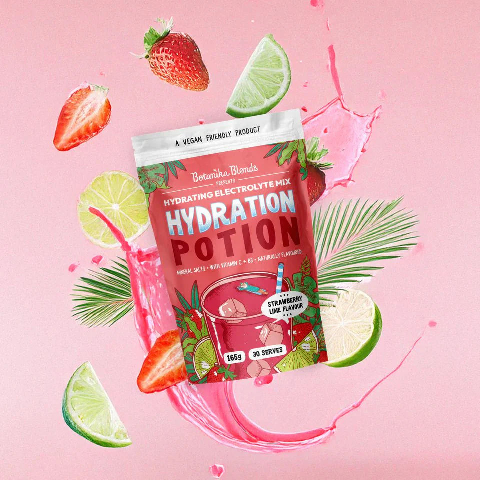 Hydration Potion Strawberry Lime - 165g by Botanika Blends surrounded by strawberries, limes, and splash on pink background