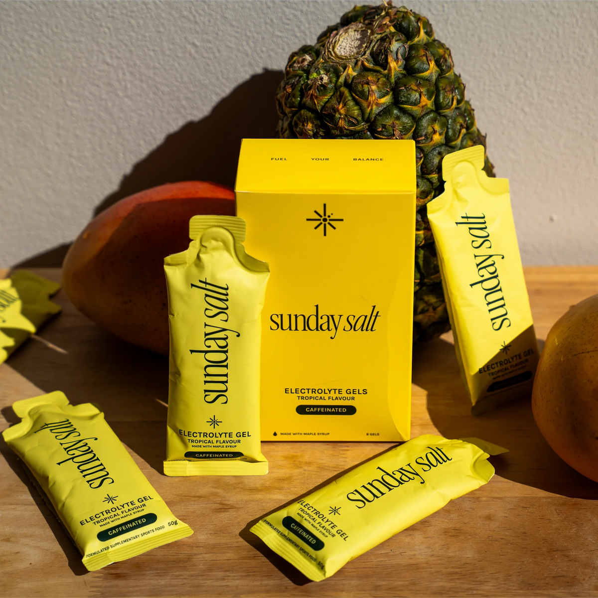 Sunday Salt Tropical β Caffeinated Energy Gel - 6 Sachets with pineapple and mango background, part of Drinks and Electrolytes collections.