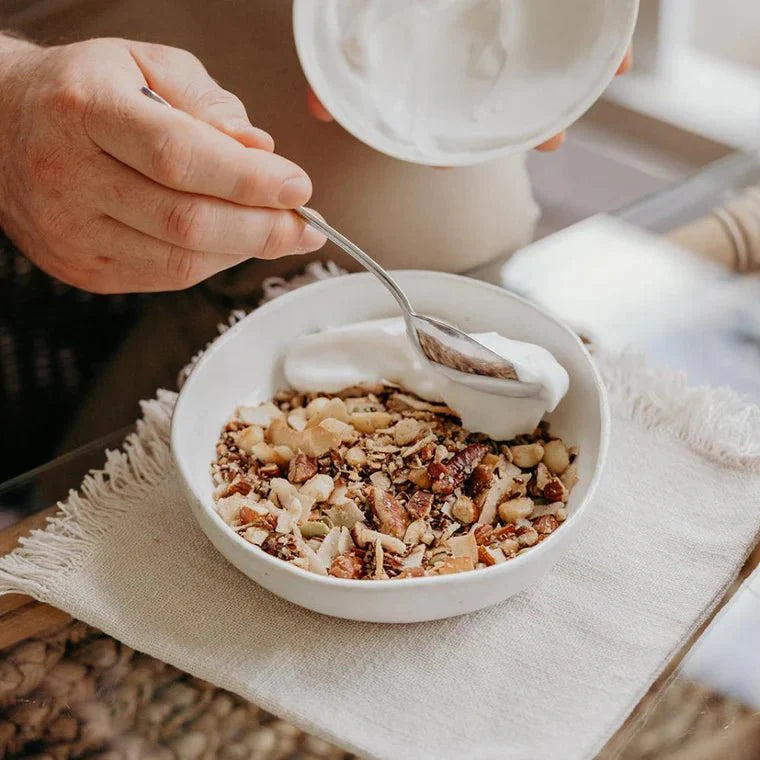 Keto Premium Paleo Granola - Macadamia & Coconut - 300g by Brookfarm served with creamy yogurt in a white bowl.