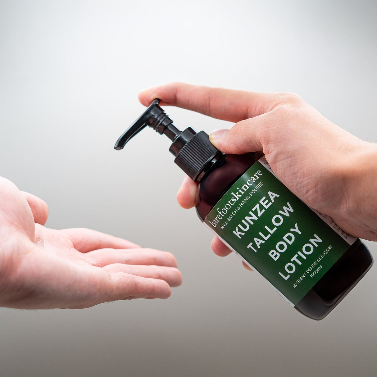 Kunzea Tallow Body Lotion - 190ml bottle being dispensed into hand, Barefoot Skincare Co product with green label