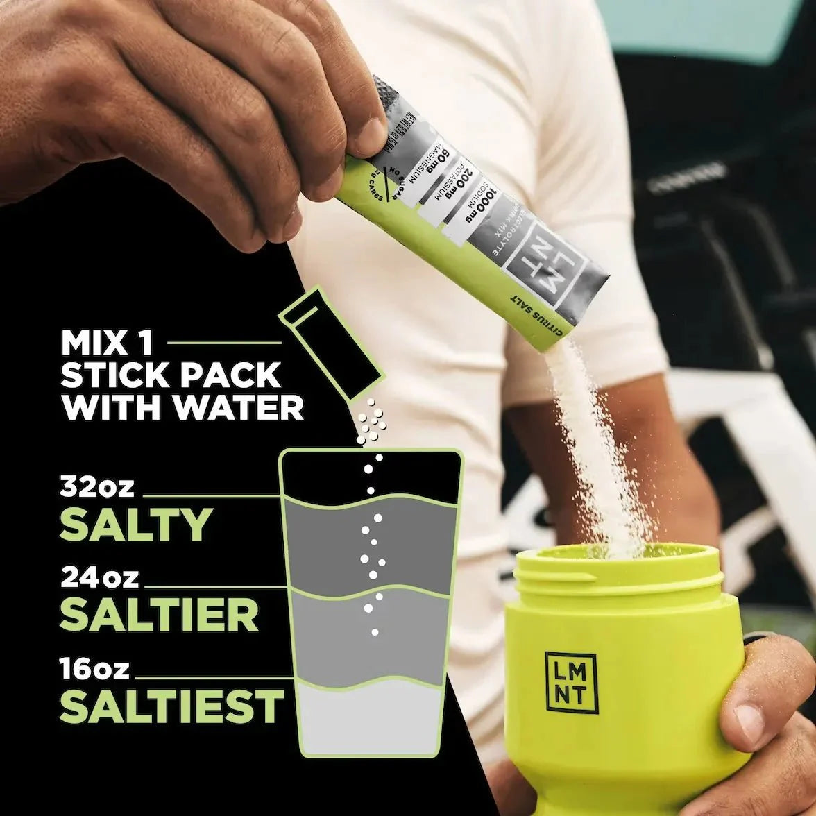 Person pouring LMNT Citrus Salt Electrolyte Mix - 30 Sticks powder into branded yellow container with hydration mixing instructions for keto and low carb.