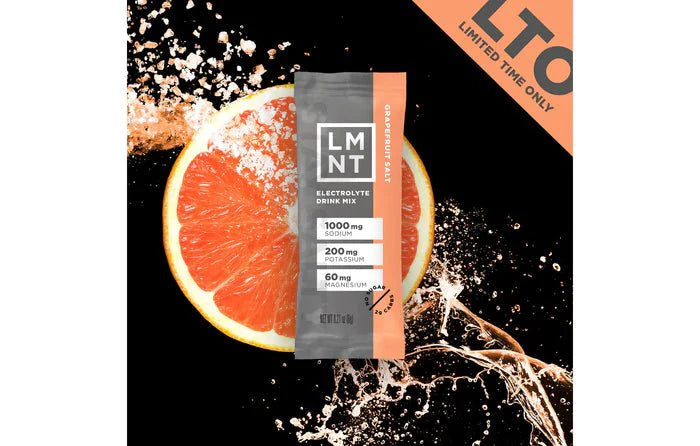 LMNT Grapefruit Salt Electrolyte Mix - 30 Sticks package with grapefruit half and splash on black background