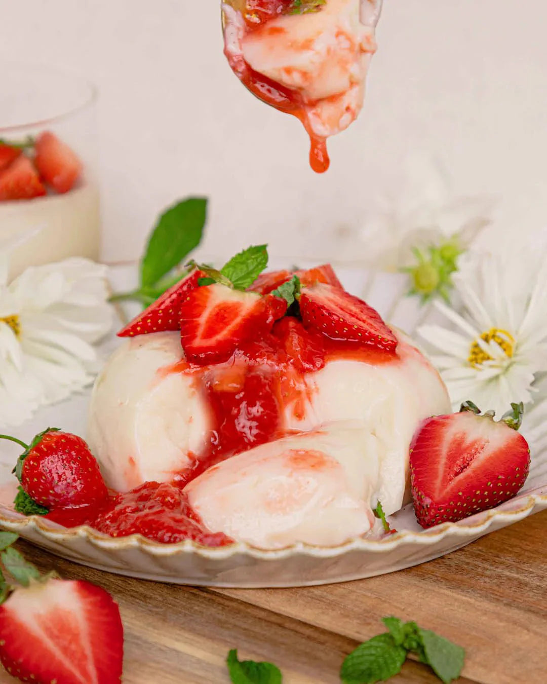 Natural Gelatin - 300g dessert topped with fresh strawberries and strawberry sauce on a plate with flowers nearby