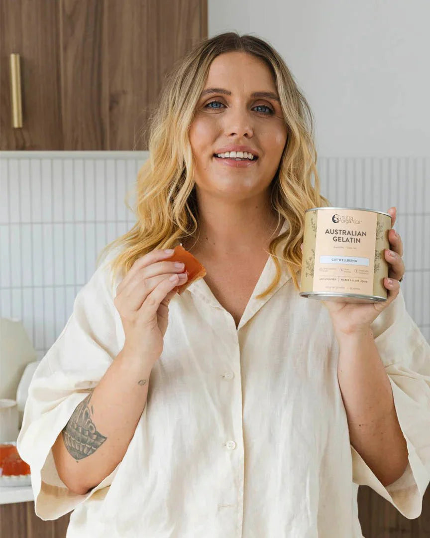 Woman holding Natural Gelatin - 300g by Nutra Organics and a jelly snack in a modern kitchen setting