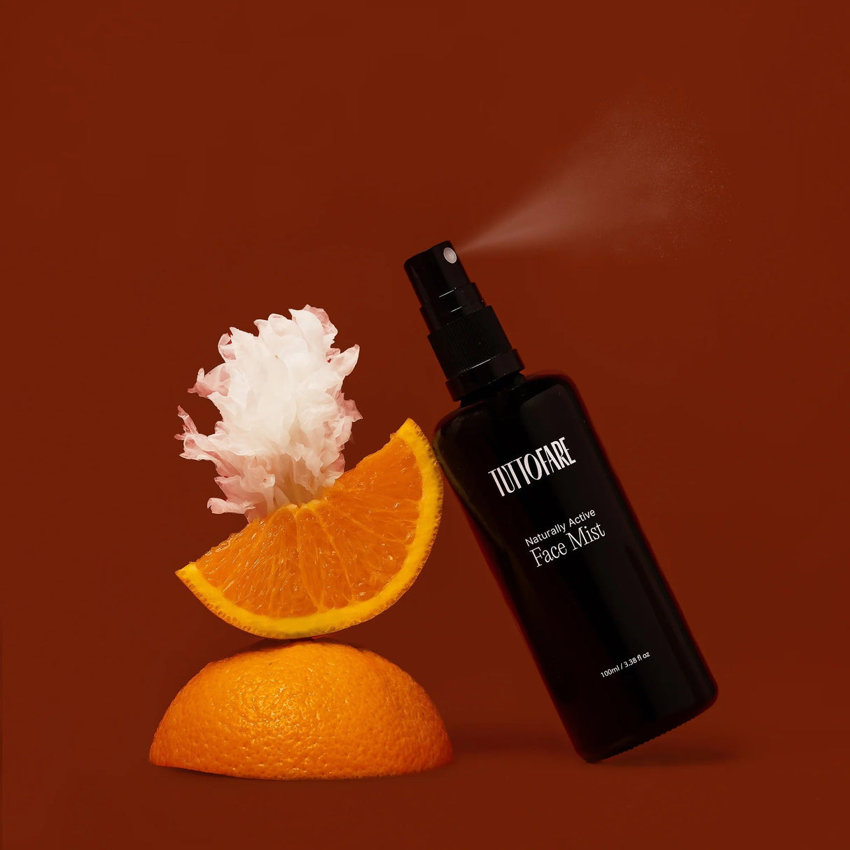 Naturally Active Face Mist - 100ml by Tuttofare spraying mist with sliced orange and white flower on brown background