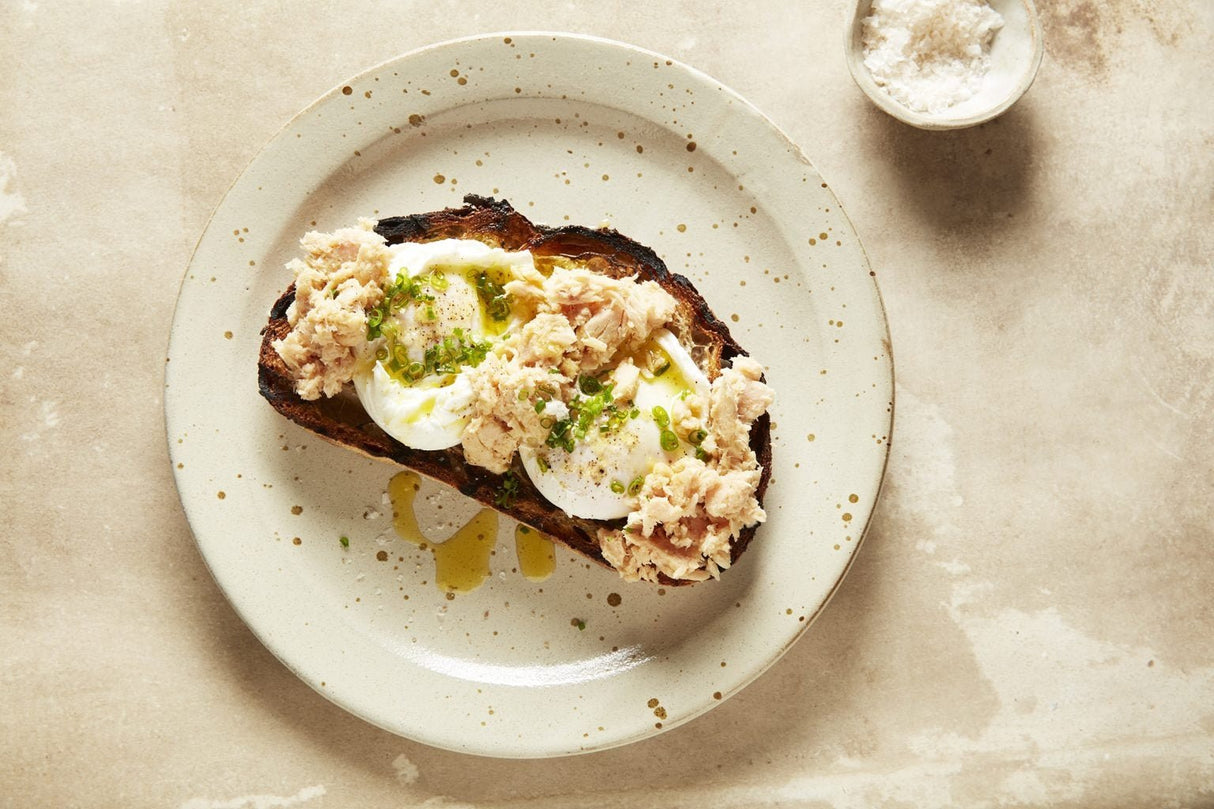 Open sandwich topped with poached eggs and Walker's Tuna Preserved Australian Albacore Tuna - 70g on a plate
