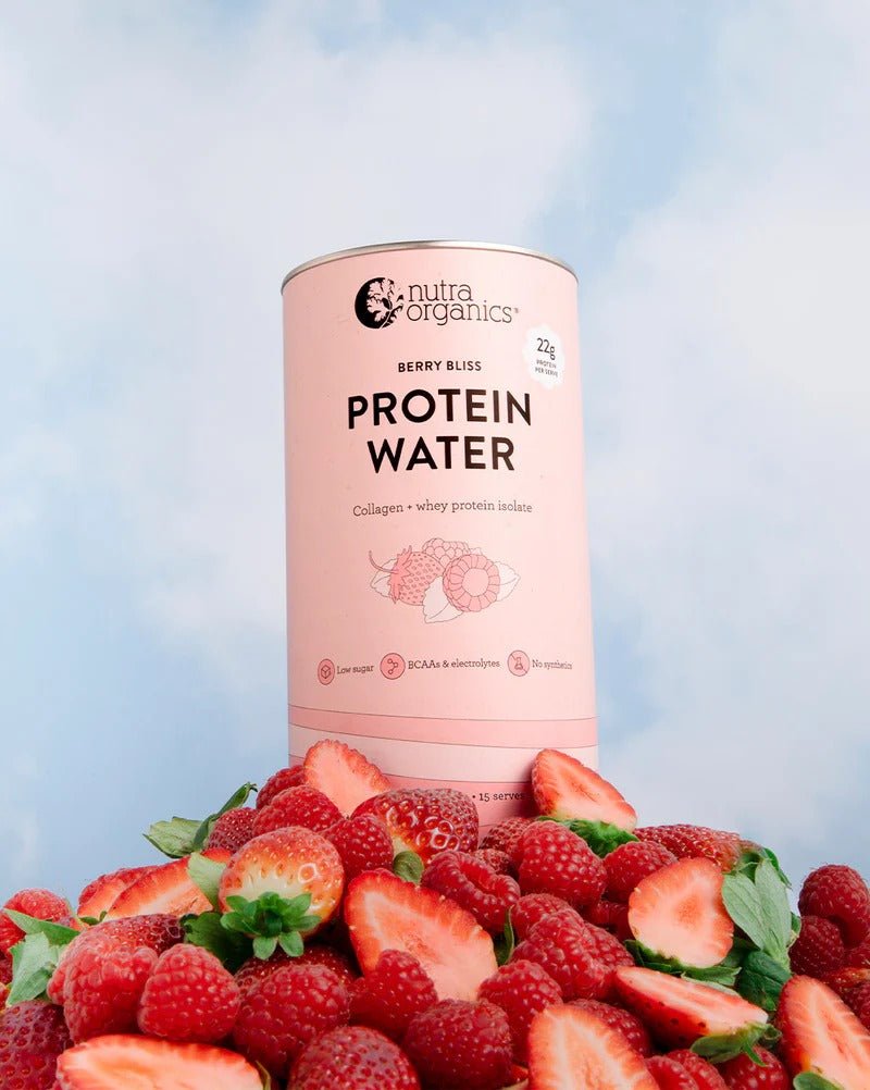 Protein Water - Berry Bliss - 450g by Nutra Organics with fresh strawberries and raspberries against blue sky background