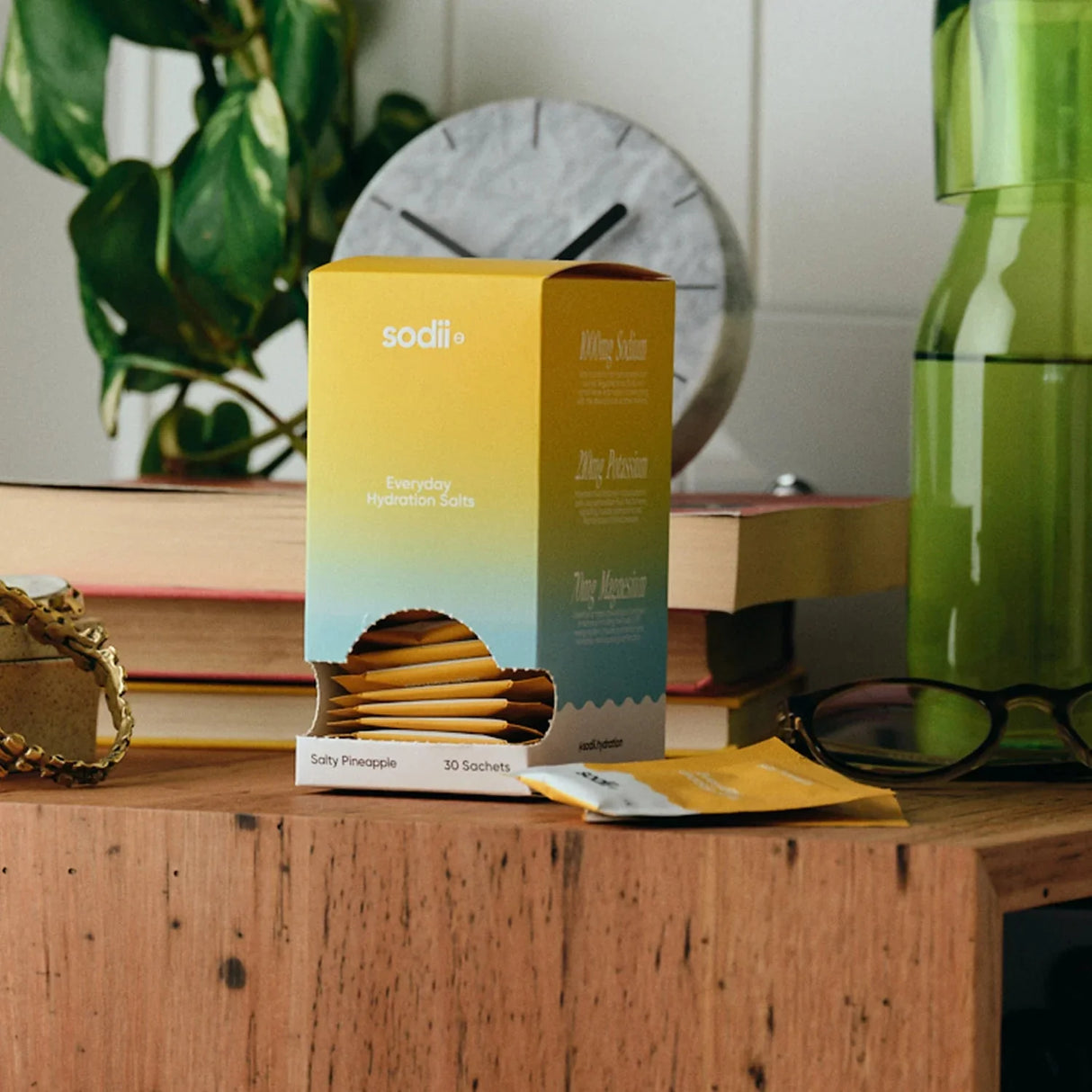 Salty Pineapple - 30 Sachets by Sodii in gradient yellow-blue box on wood table with books and glasses nearby