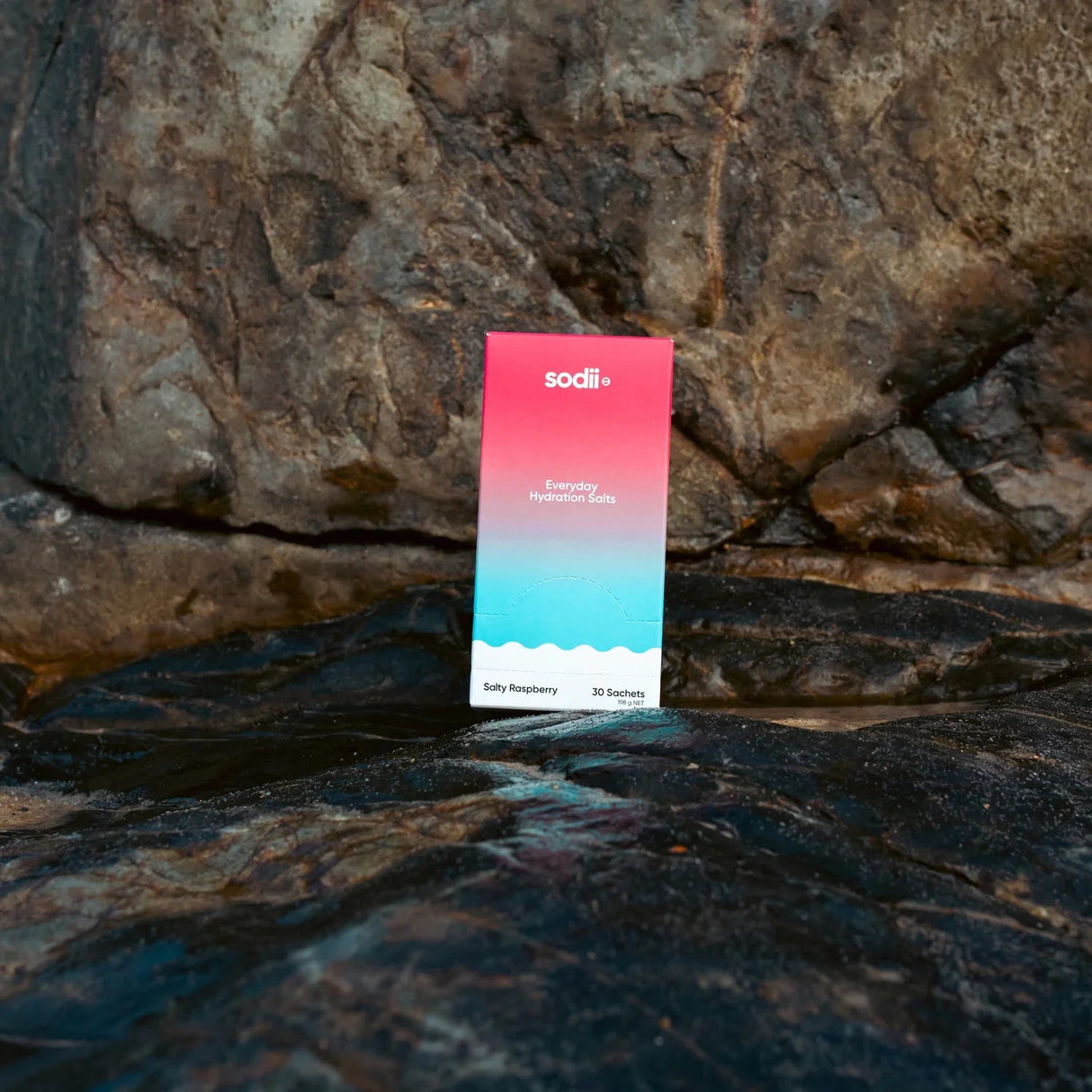 Salty Raspberry - 30 Sachets by Sodii, electrolyte hydration sachets in blue and pink box on rocky surface