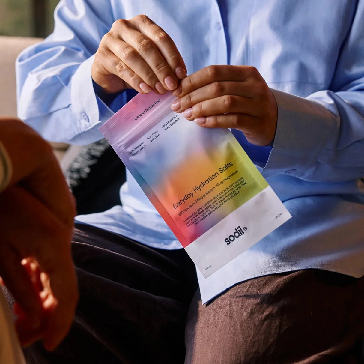 Person opening colorful Sodii hydration salts pouch from Salty Variety Pack - 8 Sachets, featuring new arrivals in electrolytes and drinks.