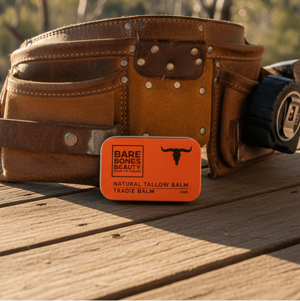 Tradie Tallow Balm - 40ml by Bare Bones Beauty displayed on a workbench with a leather tool belt in background