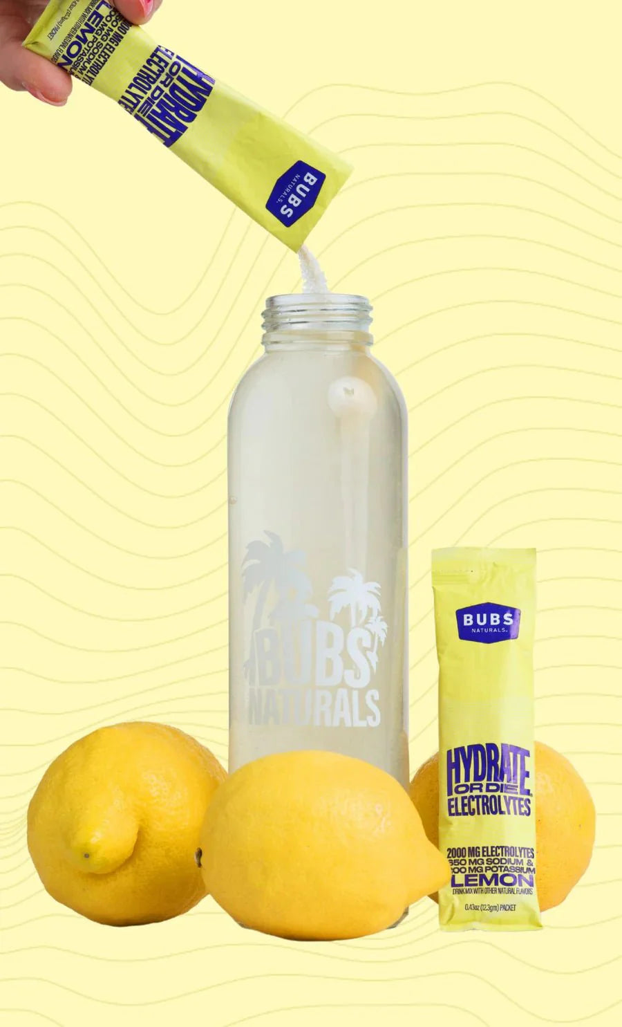 Hydrate or Die® Electrolytes Drink Mix - Lemon - 20 Sticks by BUBS Naturals with fresh lemons and water bottle.