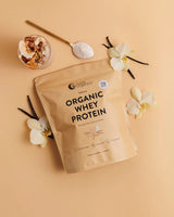 Organic Whey Protein - Vanilla - 750g pack by Nutra Organics with vanilla pods, flowers, and powder spoon on beige background