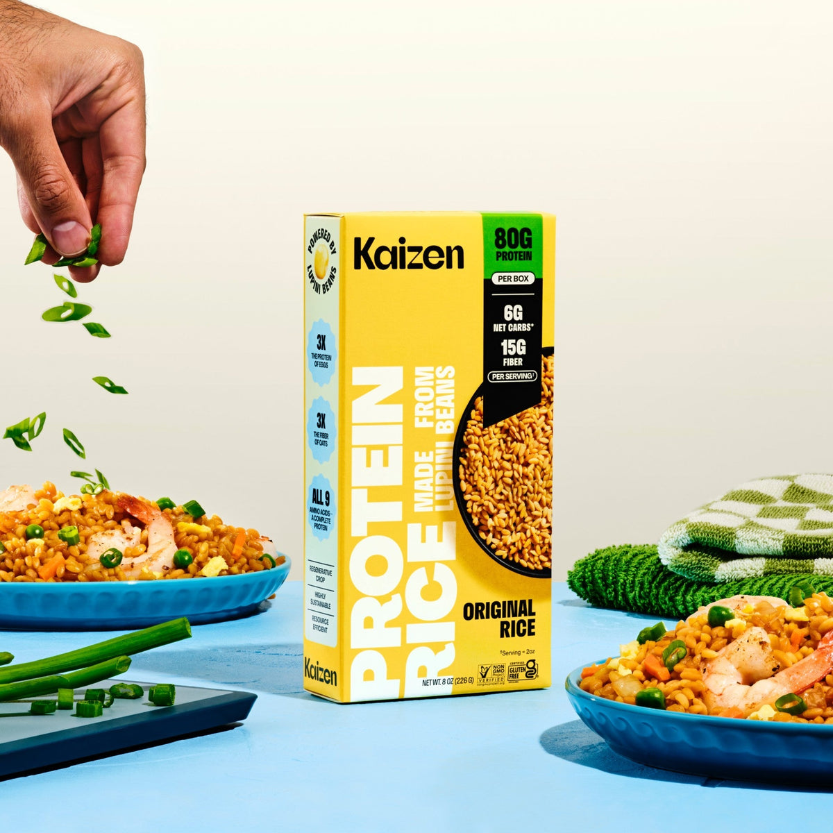 Kaizen Protein Rice Original box between two plates of fried rice with prawns and spring onion